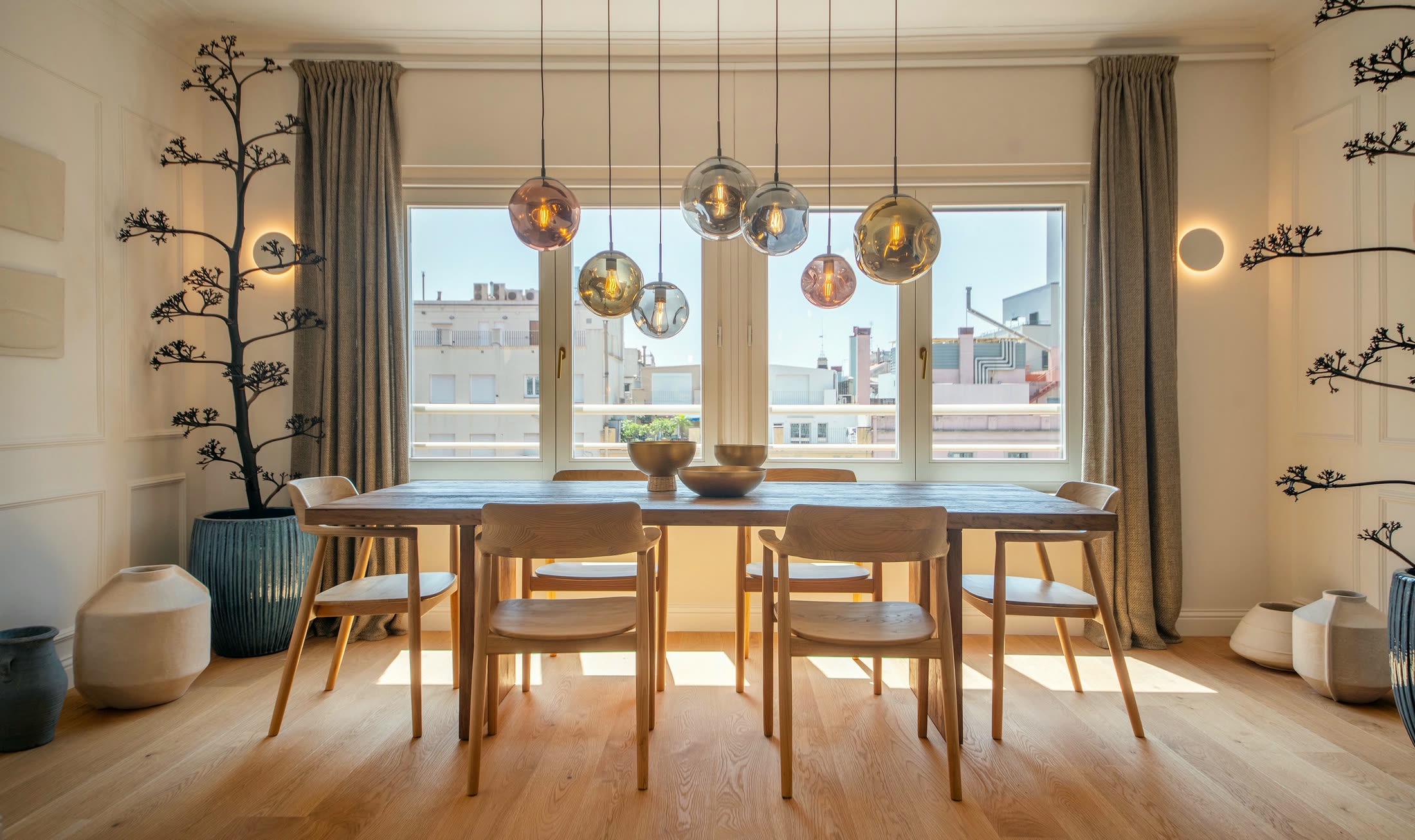 Suite Alba dining table beneath sculptural pendant lights