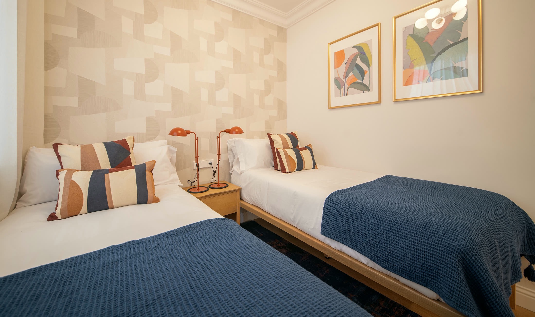 Suite Alba second bedroom with two single beds and framed artwork