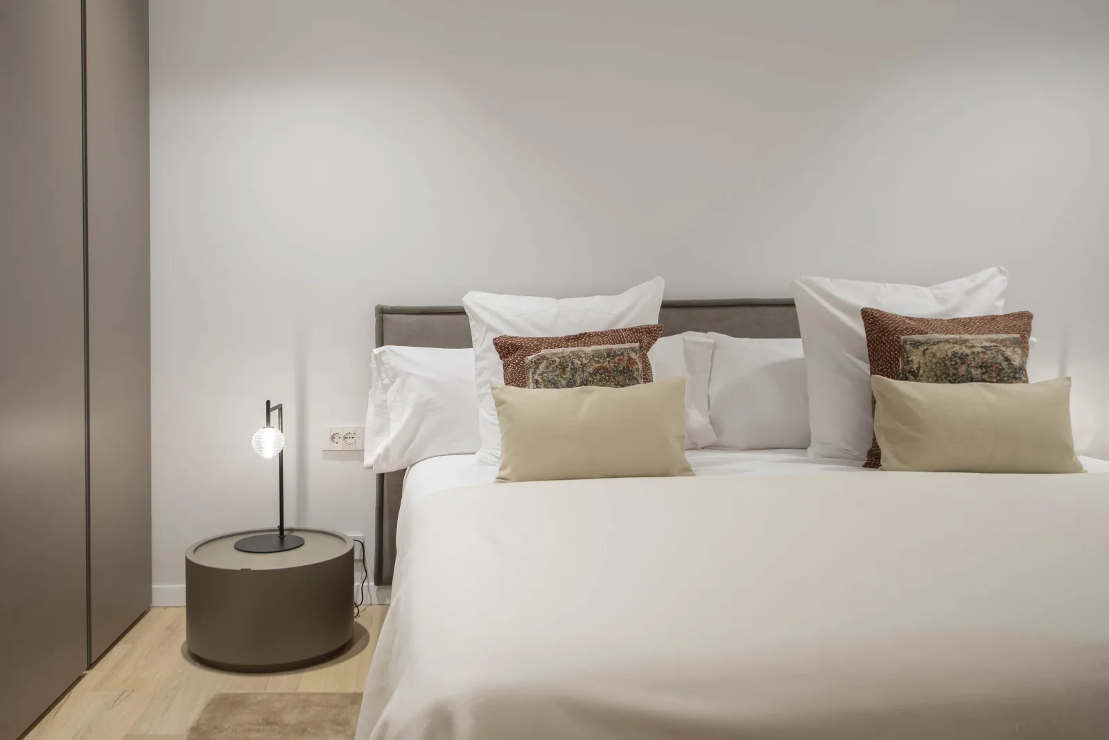 Suite Prestige second bedroom with upholstered bed and warm lighting