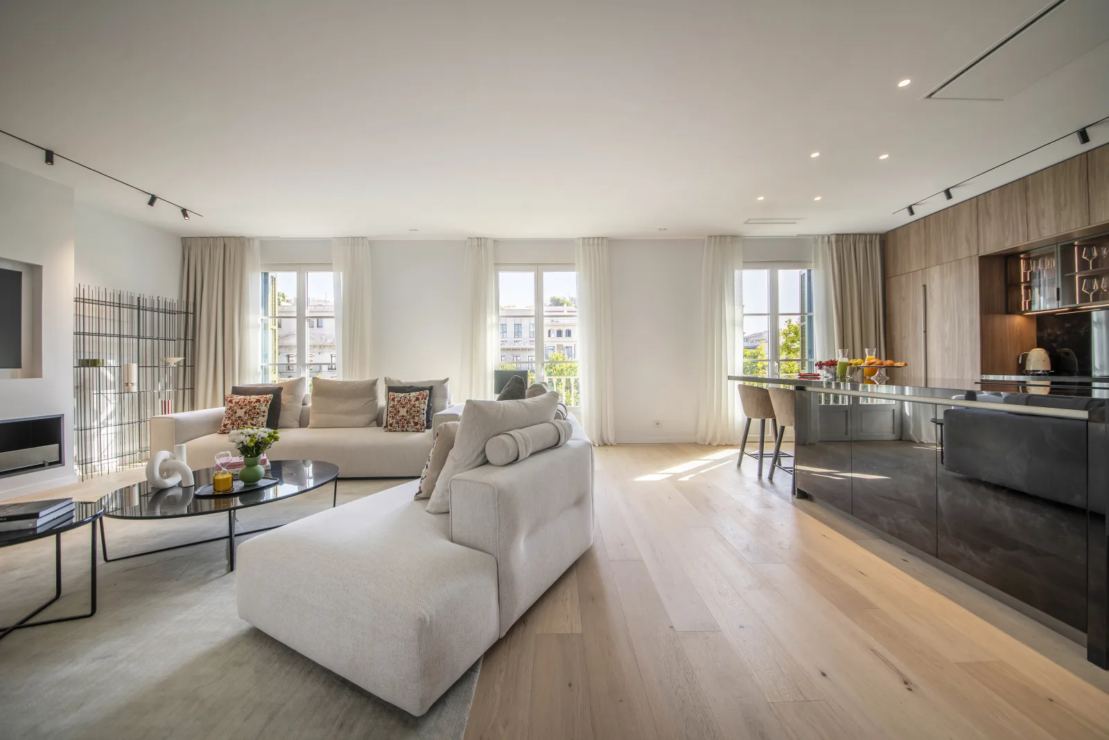 Suite Prestige open living room and kitchen with tall windows over Barcelona