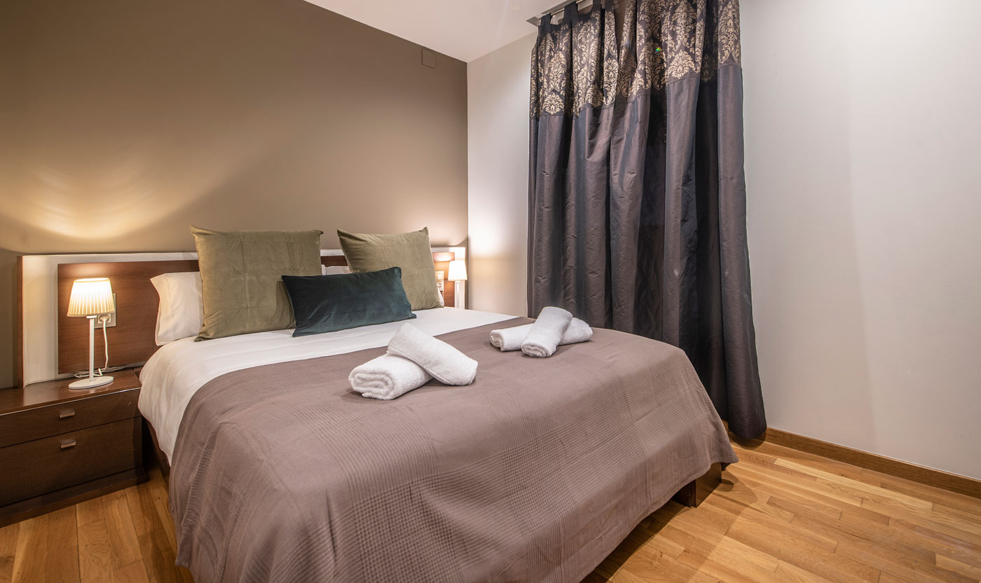 Quiet queen bedroom with folded towels in Suite Sagrada