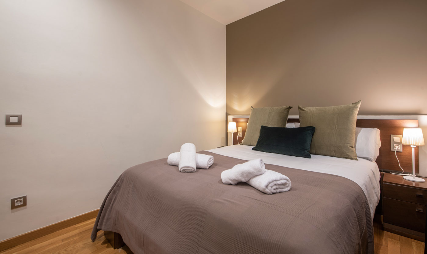 Queen bed with bedside tables in Suite Sagrada