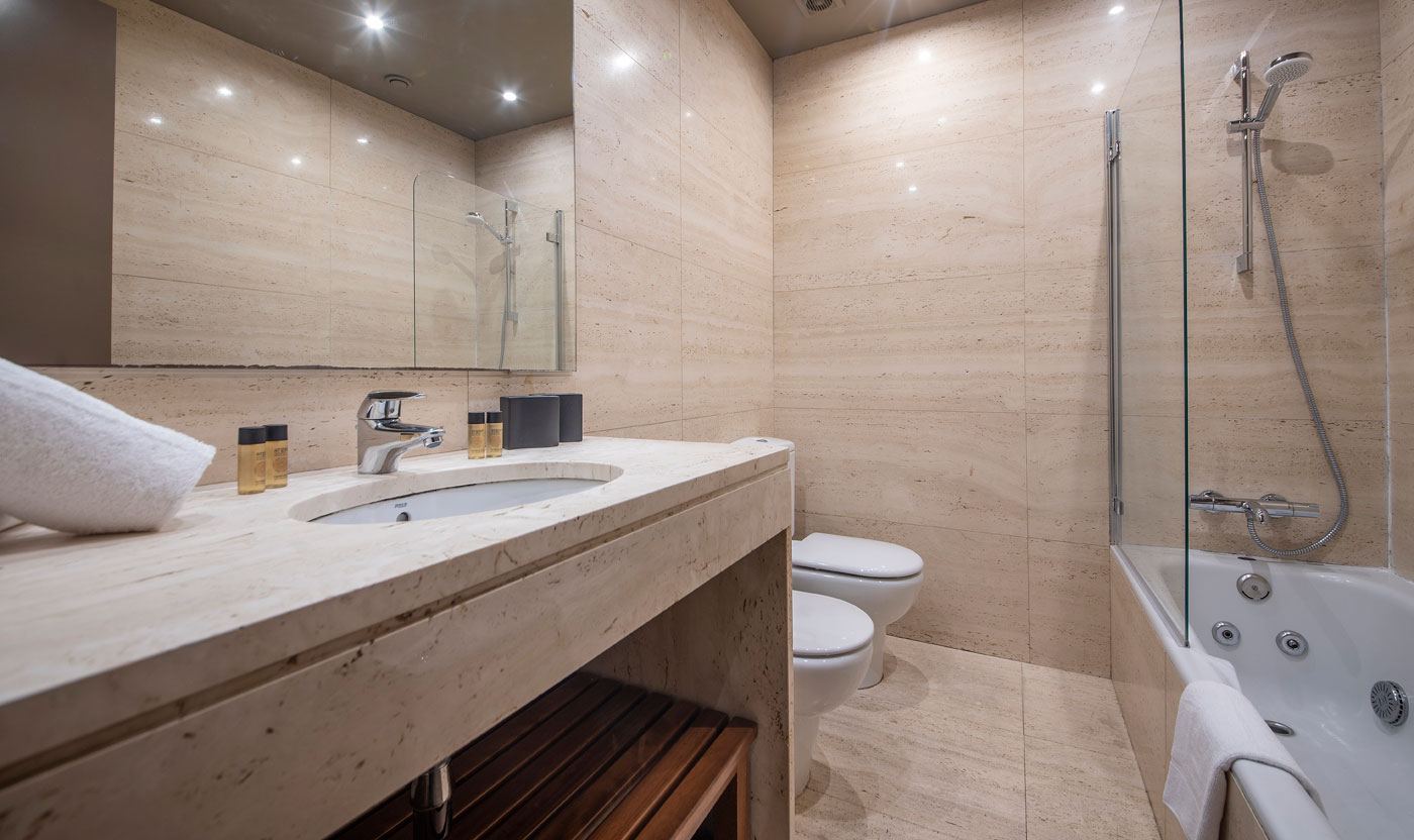 En suite bathroom with tub and shower in Suite Sagrada