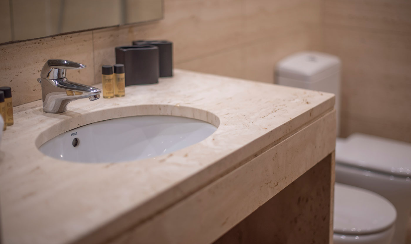 Stone sink and mirror in the Suite Sagrada en suite bathroom