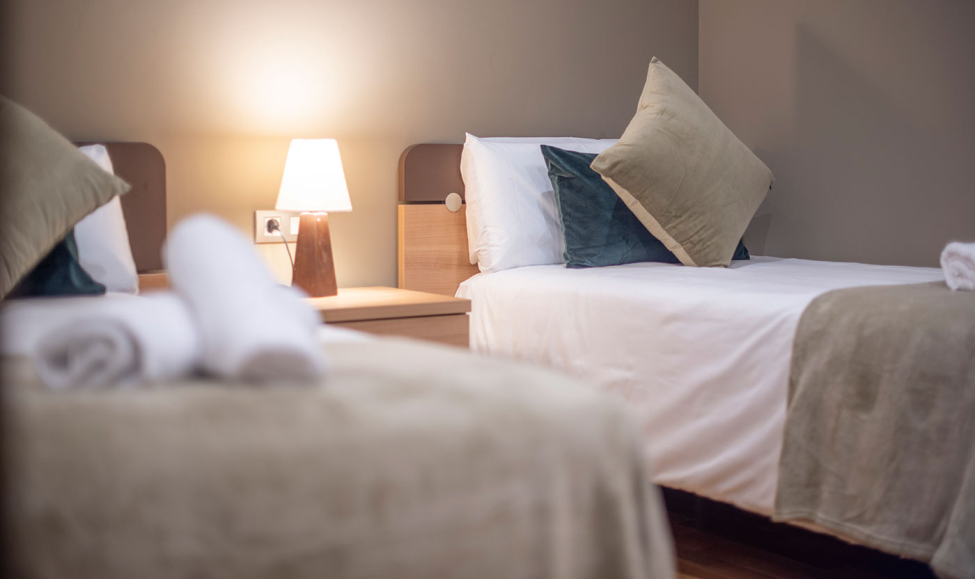 Single beds and bedside lamp in the Suite Sagrada twin room