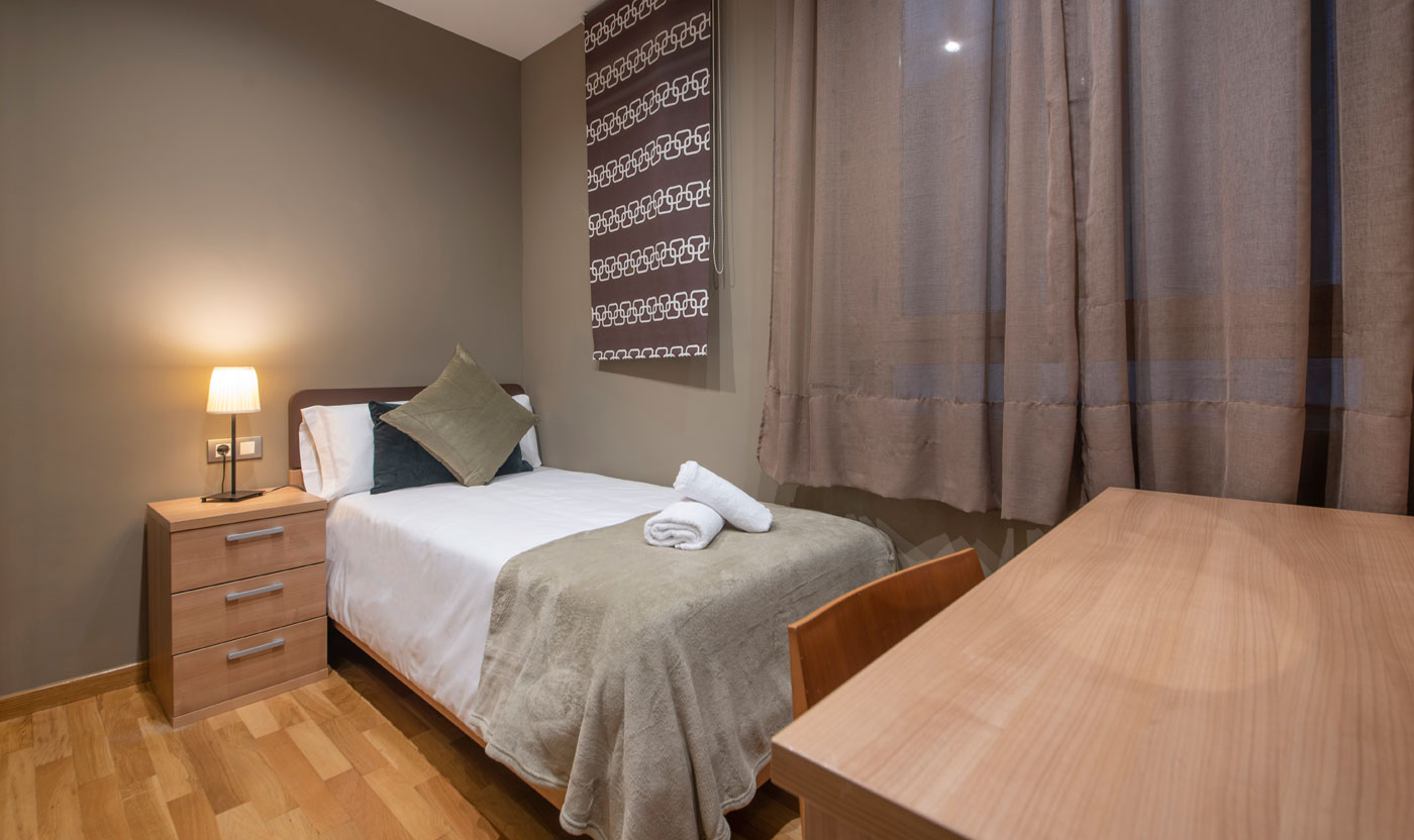 Single bedroom with desk and wardrobe in Suite Sagrada
