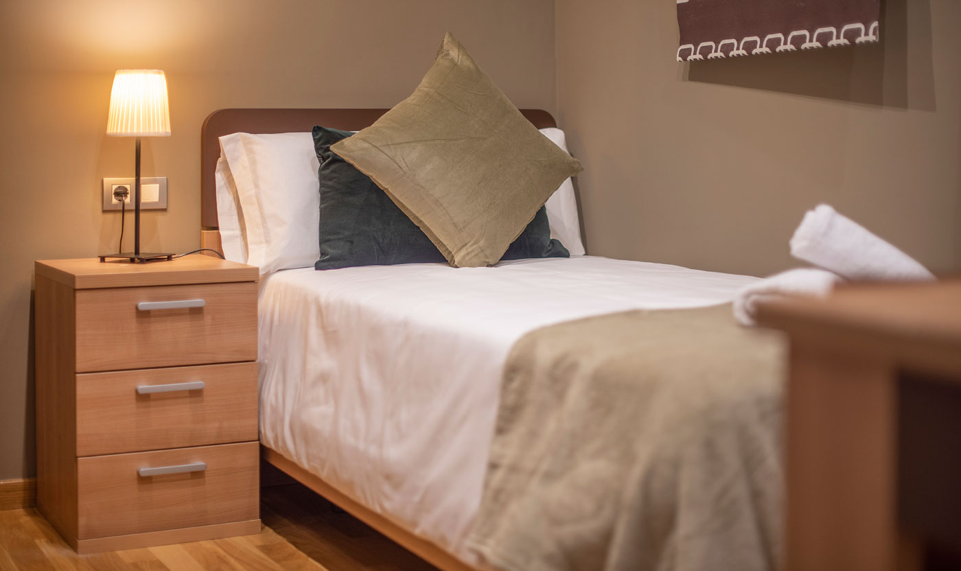 Single bed and bedside table in Suite Sagrada