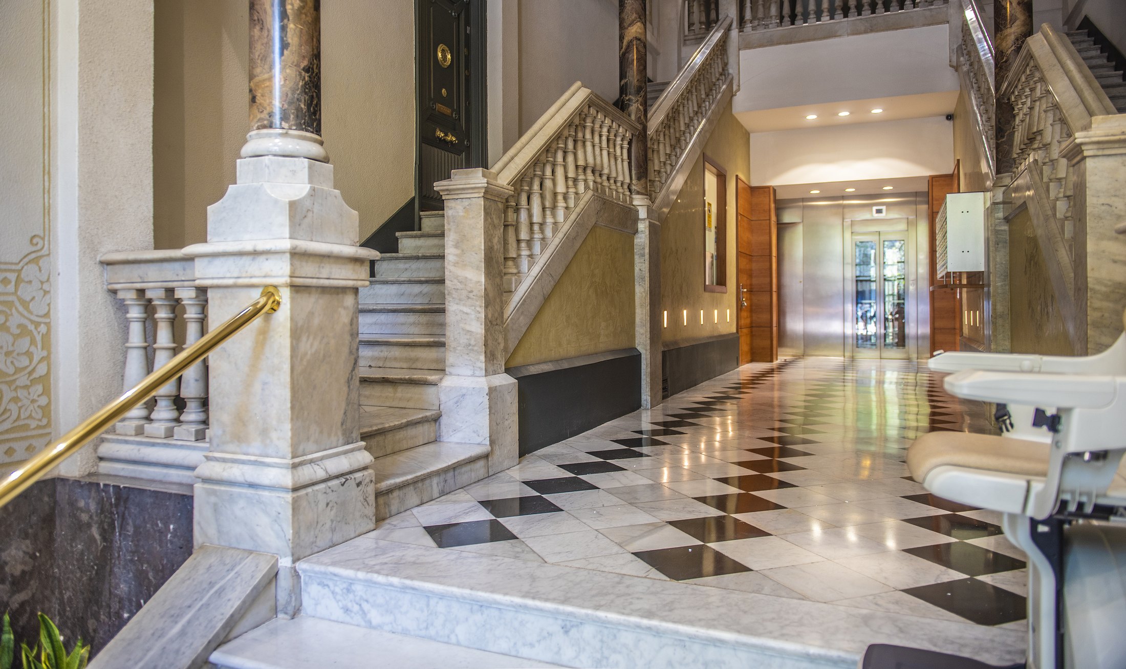 Marble staircase and chequered floor inside the entrance at Passeig de Gr&agrave;cia 15