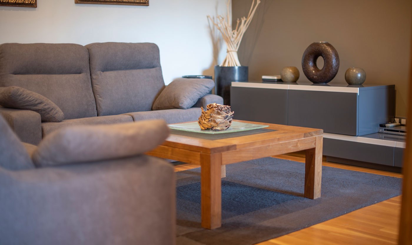 Timber coffee table and grey sofas in Suite Sol&eacute;a