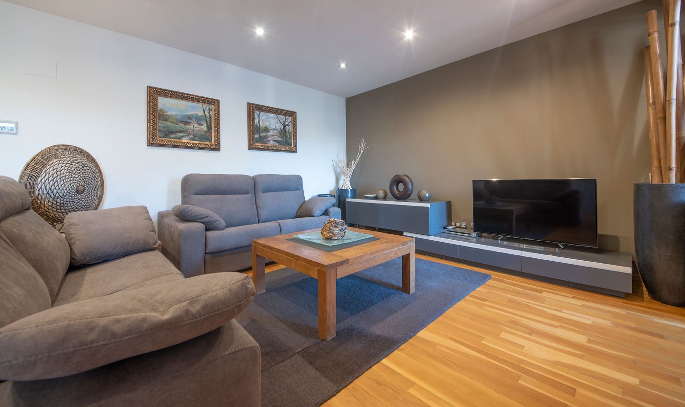 Grey sofas and television in the Suite Sol&eacute;a living room