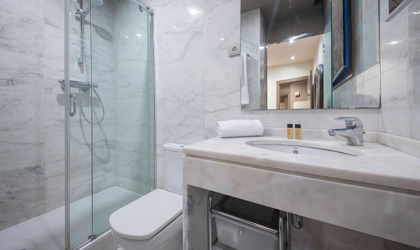 Marble en suite bathroom with glass walk-in shower in Suite Sol&eacute;a