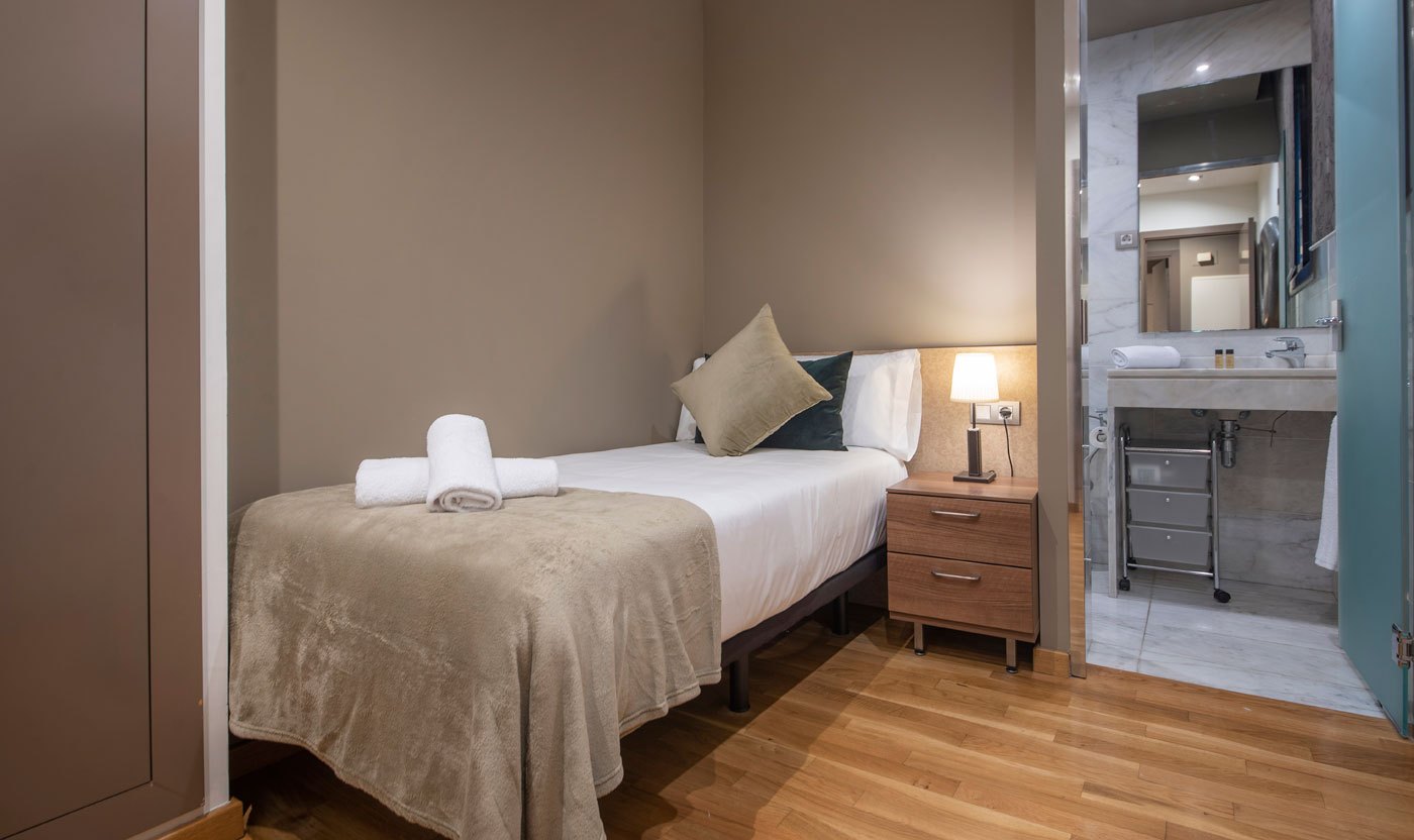Second bedroom in Suite Sol&eacute;a with a single bed beside a marble bathroom